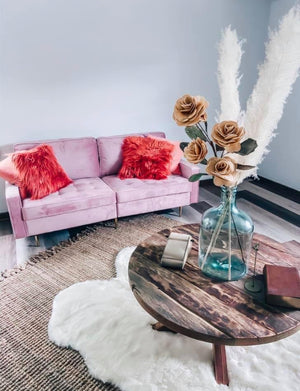 boutique shop for womens clothing, shabby chic setting with pink sofa and pampas grass floral arrangements, a fuzzy white rug and rustic wooden table give this place a southern country and classy atmosphere you are sure to enjoy
